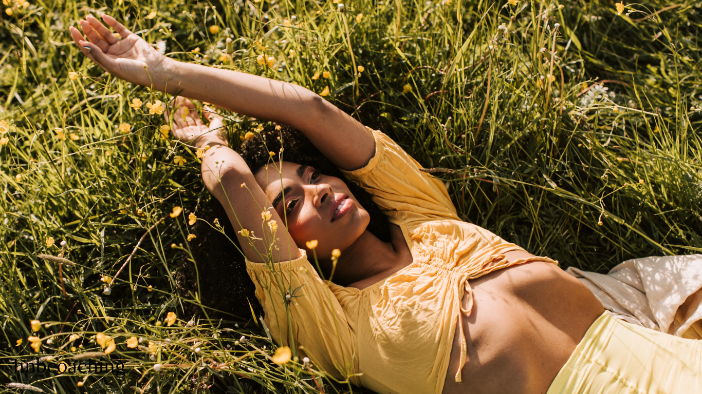 femme allongée au sol dans l'herbe, elle se reconnecte à elle même